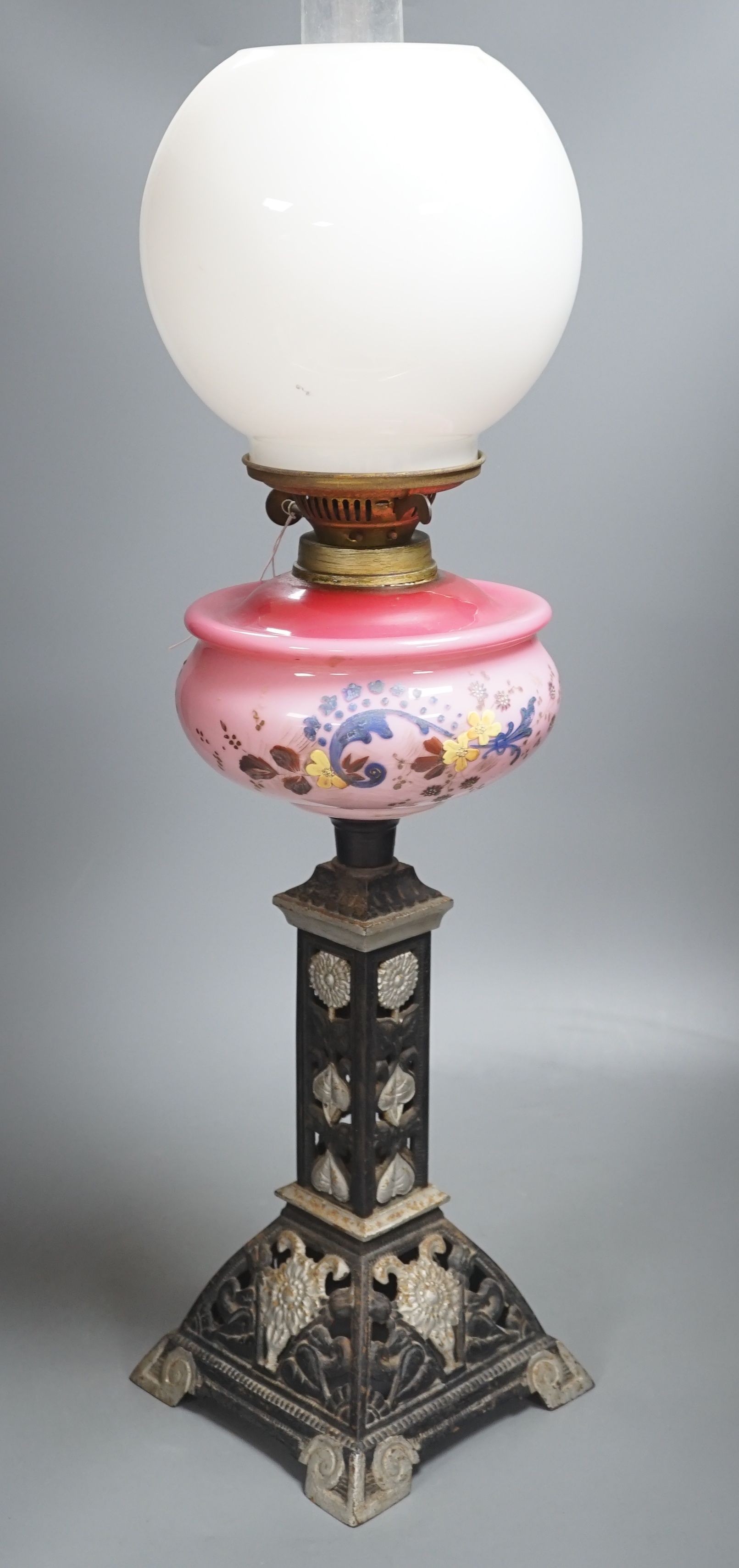 A Victorian cast iron and enamelled glass oil lamp